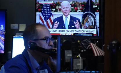 FILE - President Jose Biden appears on a screen as trader Mark Puetzer works on the floor of the New York Stock Exchange, Nov. 29, 2021. (AP Photo/Richard Drew, File)