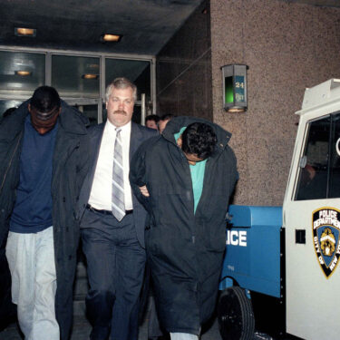 In this April 22, 1989 file photo, Yusef Salaam, 15, second from left, and Raymond Santana, 14, right, are led from the 24th Precinct by a detective after their arrest in connection with the rape and severe beating of a woman jogging in Central Park. (AP Photo/David Burns, File)